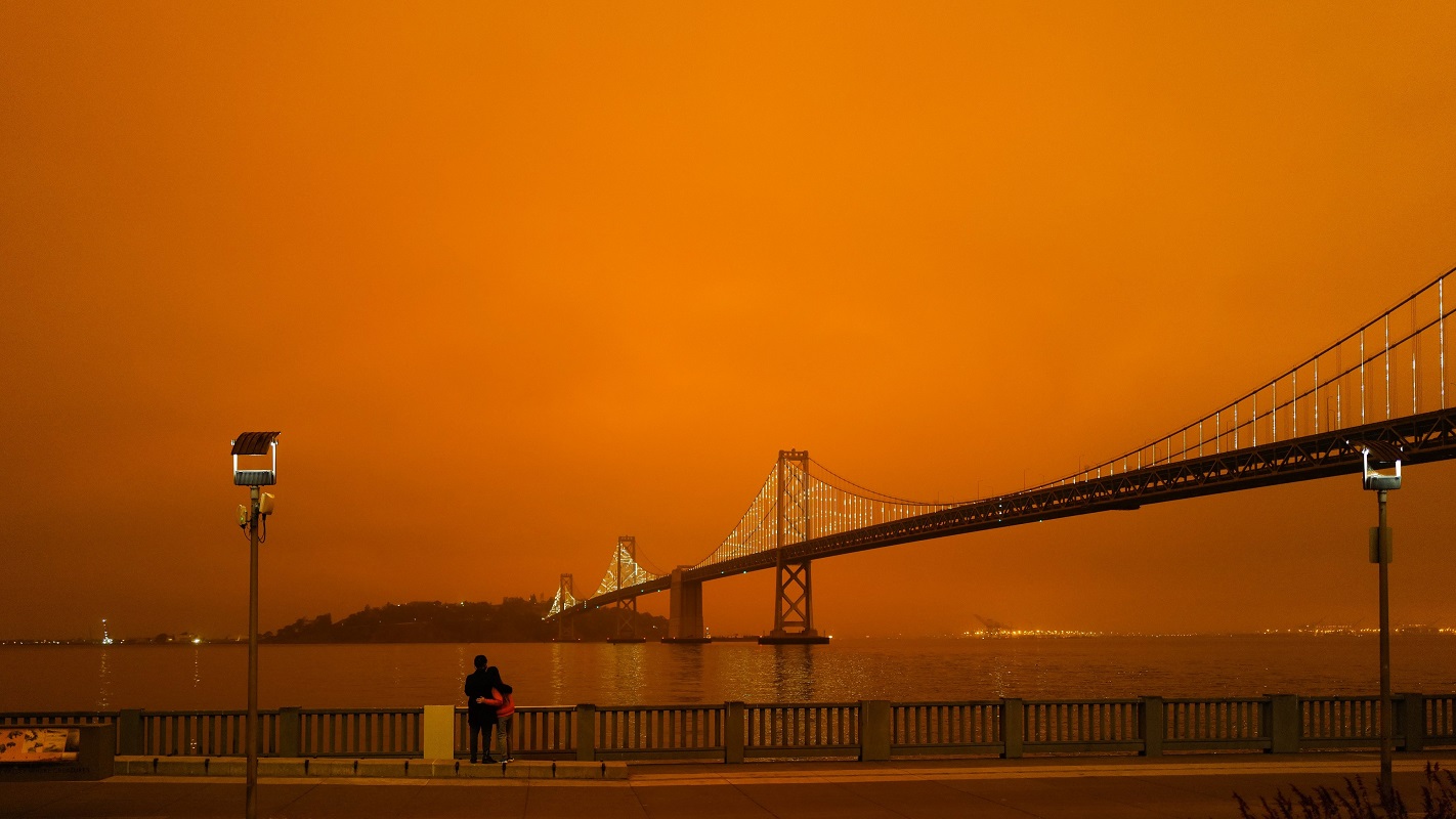 An orange sky from wildfires backlights the Golden Gate Bridge on a night in San Francisco.
